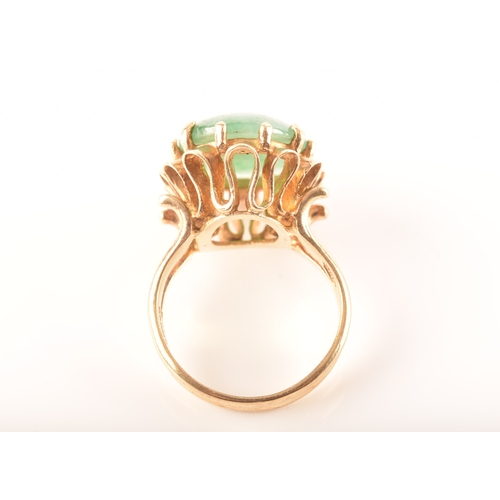 101 - A 9ct gold jadeite ring, set with oval cabochon jadeite measuring approximately 16 x 12mm, in a intr... 