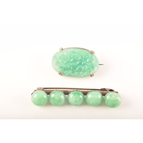 103 - A silver and jade brooches, including a oval carved jade brooch with an ornate floral design, togeth... 