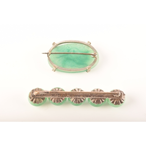 103 - A silver and jade brooches, including a oval carved jade brooch with an ornate floral design, togeth... 