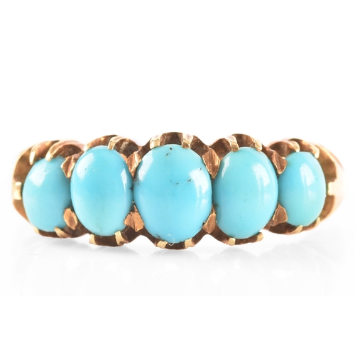 104 - A yellow metal ring, set with five oval cabochon turquoise, size N.