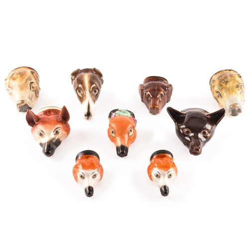 314 - A collection of Staffordshire stirrup cups, including various dogs and foxes, largest 16cm long.