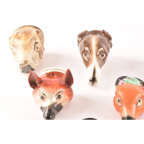 314 - A collection of Staffordshire stirrup cups, including various dogs and foxes, largest 16cm long.