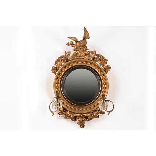 389 - A 19th century convex gilt wall mirror, crested with a carved and gilded dragon and snake, and scrol... 