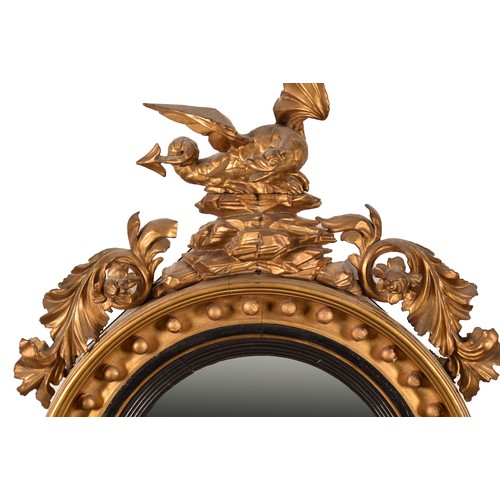 389 - A 19th century convex gilt wall mirror, crested with a carved and gilded dragon and snake, and scrol... 