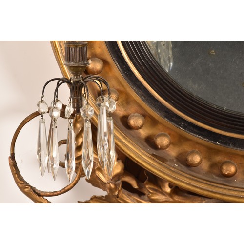 389 - A 19th century convex gilt wall mirror, crested with a carved and gilded dragon and snake, and scrol... 