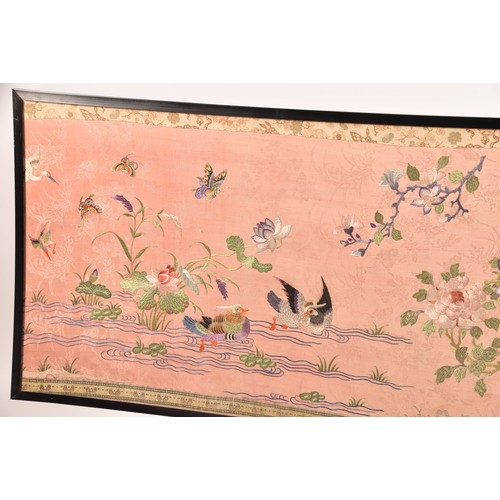 297 - A large Chinese silk work picture, decorated with a central scene of an Asiatic pheasant stood on a ... 