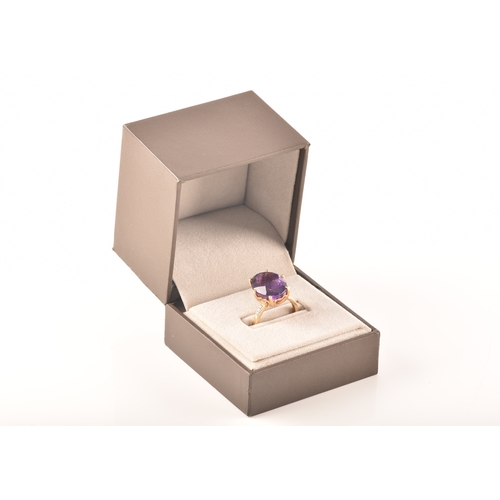 32 - A large 18ct yellow gold amethyst solitaire ring, set to centre with a oval checkerboard cut amethys... 