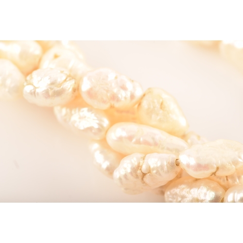 12 - A twisted four strand freshwater pearl necklace, with 14ct yellow gold clasp, 79cm long.