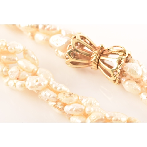 12 - A twisted four strand freshwater pearl necklace, with 14ct yellow gold clasp, 79cm long.