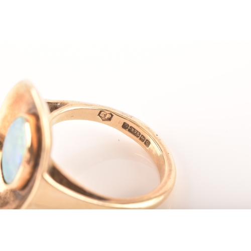 91 - A 9ct yellow gold dress ring with a concave oval design, set to centre with a opal measuring approxi... 