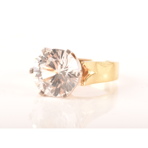 14 - An 18ct yellow gold solitaire ring set with a round cut synthetic white sapphire with an approximate... 