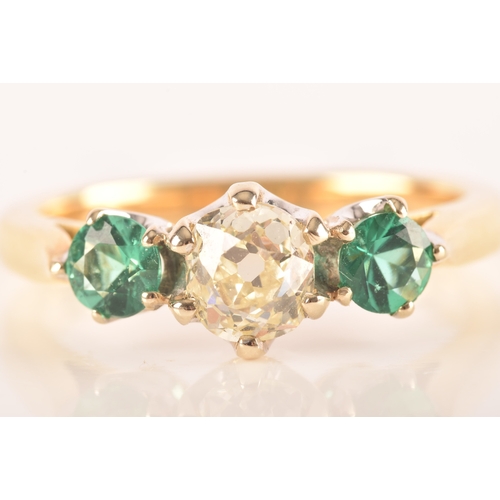 42 - A diamond and emerald three stone ring, set to centre with a cushion shape old mine diamond with an ... 