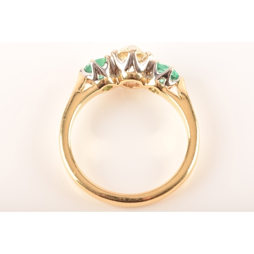 42 - A diamond and emerald three stone ring, set to centre with a cushion shape old mine diamond with an ... 