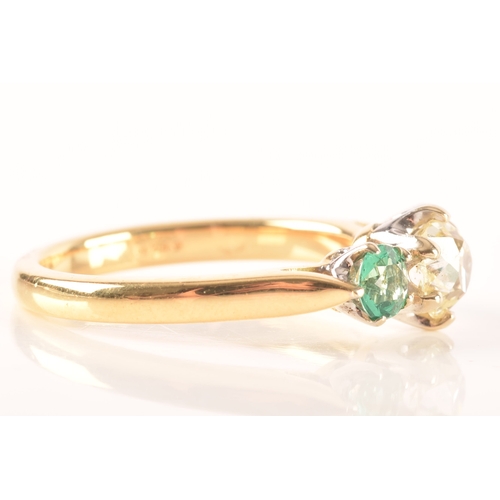 42 - A diamond and emerald three stone ring, set to centre with a cushion shape old mine diamond with an ... 