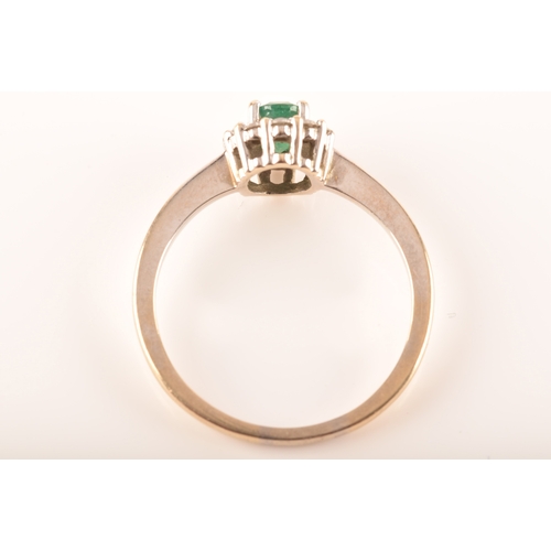 87 - An 18ct white gold emerald and diamond oval coronet cluster, set with centre with an oval emerald wi... 