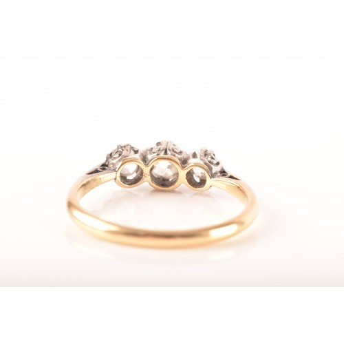 45 - A 18ct yellow gold and white metal three stone diamond ring, set with three round old cut diamonds, ... 