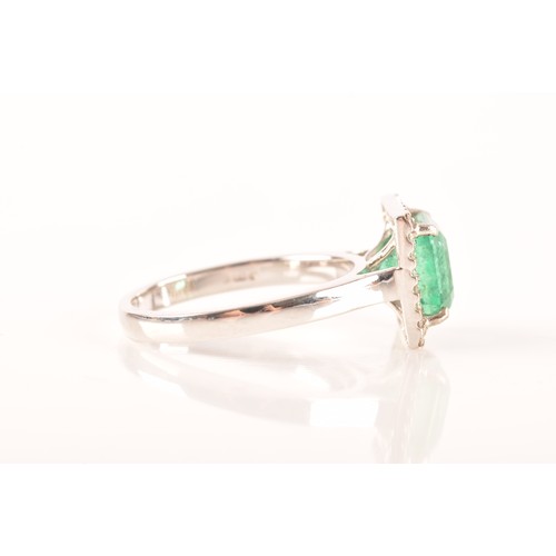 47 - A 18ct white gold emerald and diamond ring, set to centre with a hexagonal cut emerald with an appro... 