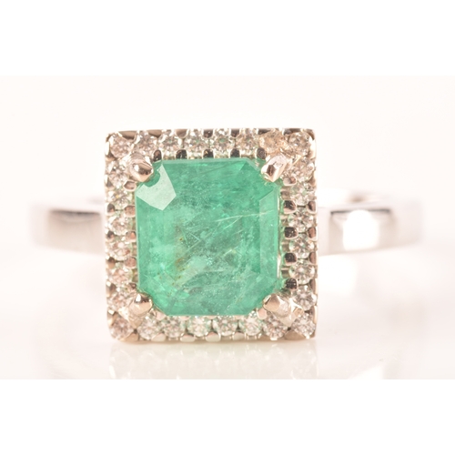 47 - A 18ct white gold emerald and diamond ring, set to centre with a hexagonal cut emerald with an appro... 