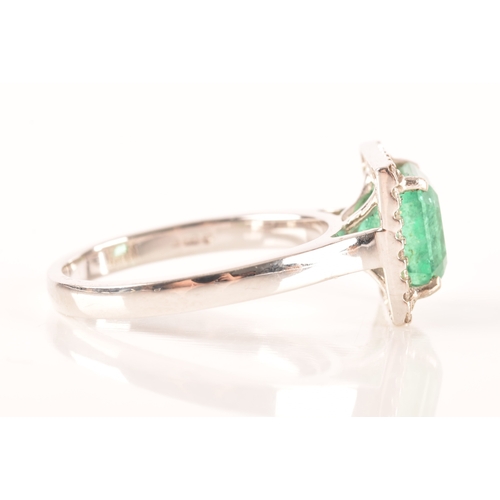 47 - A 18ct white gold emerald and diamond ring, set to centre with a hexagonal cut emerald with an appro... 