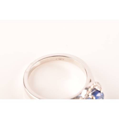 49 - An 18ct white gold sapphire and diamond oval cluster, set to centre with a oval cut blue sapphire wi... 