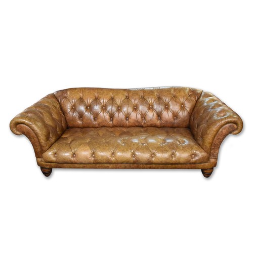 382 - A large brown leather button back Chesterfield style sofa, supported on turned wooden legs, 229 cm w... 