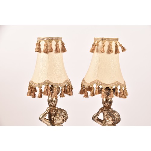 385 - A pair of decorative silvered cherub table lamps, plaster formed as cherubs holding aloft sconces, 6... 