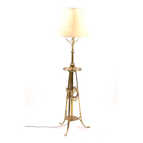 387 - A Victorian style brass standard lamp, with shaped arms, circular mid-level shelf, supported on a tr... 