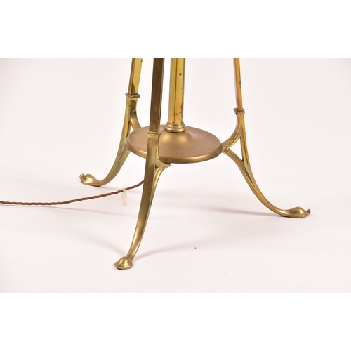 387 - A Victorian style brass standard lamp, with shaped arms, circular mid-level shelf, supported on a tr... 