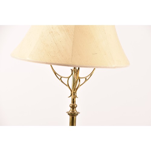 387 - A Victorian style brass standard lamp, with shaped arms, circular mid-level shelf, supported on a tr... 