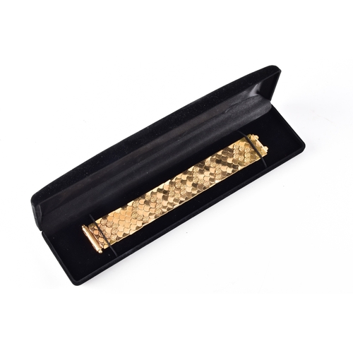 A mid 20th century 18ct yellow gold wide, articulated reversible bracelet, composed of overlapping scalloped panels forming a flexible scale-like design, one side with a polished repeating scallop pattern, the reverse decorated with textured fan motifs arranged in clustered bands, with concealed clasp, marked '750' and '224VI' 2.6 cm wide, length 18 cm.