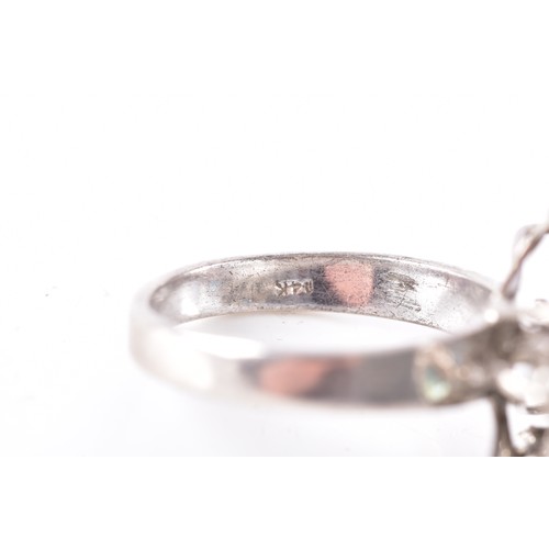 66 - A white metal, sapphire, and white paste stone cluster ring, the ribbon twist mount set with six mix... 