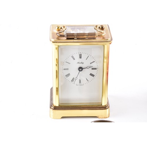 212 - A Henley gilt carriage clock with key, 11 cm high, two commemorative crowns, a silver engraved bangl... 