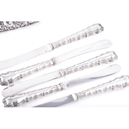 158 - A silver backed hand mirror and hair brush, with repousse decoration featuring leaves, masks, and bi... 