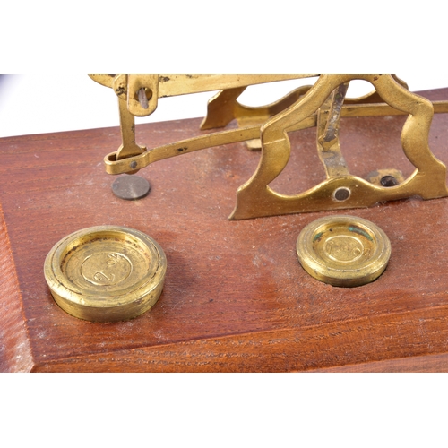 214 - Two late 19th to early 20th century brass postal balance scales, each with twin circular pans on a b... 
