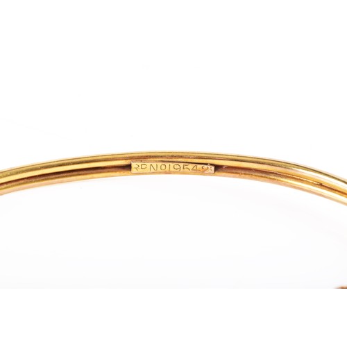 52 - A 9ct bi-colour yellow and rose gold entwined bangle, diameter approximately 5.8 cm, fitted with saf... 