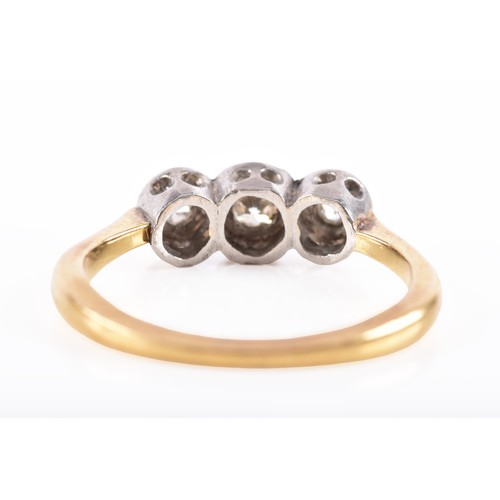 57 - An 18ct yellow gold and platinum diamond three stone ring, set with three graduating round brilliant... 