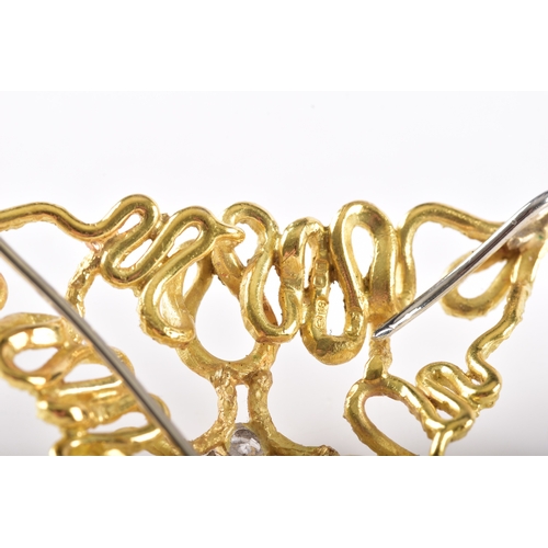 5 - An 18ct gold brooch of triangular openwork design, formed of textured scrolling wirework, centred wi... 