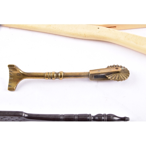 217 - A vintage brass pastry tool, a celluloid glove stretcher, together with a antique iron nut cracker. ... 