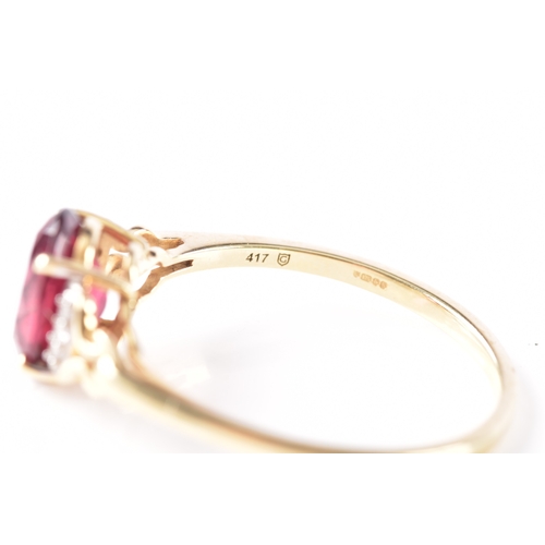 21 - A 9ct yellow gold garnet ring, featuring intricate openwork shoulders set with six small white stone... 