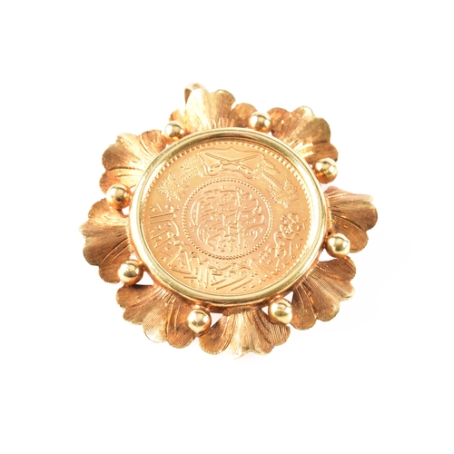 31 - A Saudi Arabian gold guinea coin, set in a 18ct yellow gold pendant/brooch mount, 3.5 cm diameter.