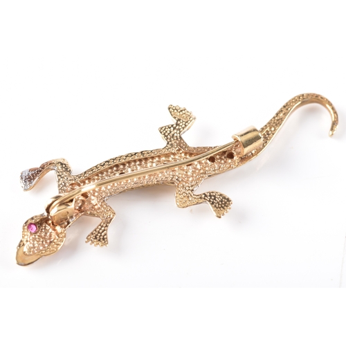 32 - A Gold and Diamond Lizard Brooch, featurng a diamond set spin, ruby eyes and a patterned tail, fitte... 