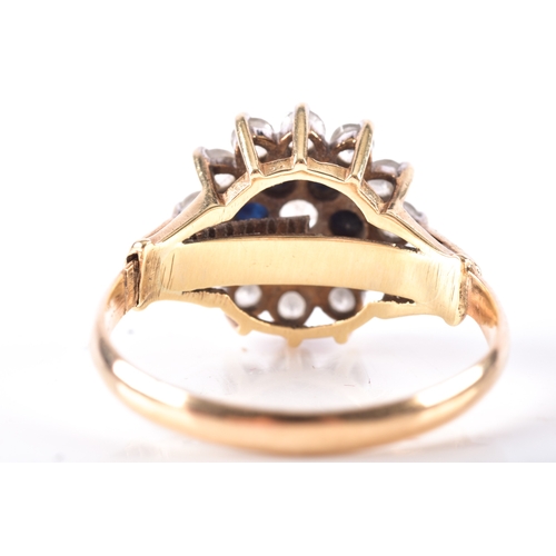 15 - A 9ct yellow gold sapphire and white stone floral cluster ring, leading to raised leaf motif shoulde... 
