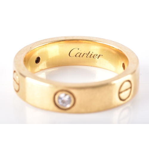 16 - Cartier. An 18ct yellow gold Love ring, with round brilliant cut diamond trio and screw head motif s... 