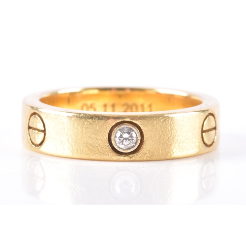 16 - Cartier. An 18ct yellow gold Love ring, with round brilliant cut diamond trio and screw head motif s... 