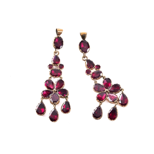 62 - A pair of Victorian-style yellow metal and almandine garnet pendant earrings, each of floral cluster... 