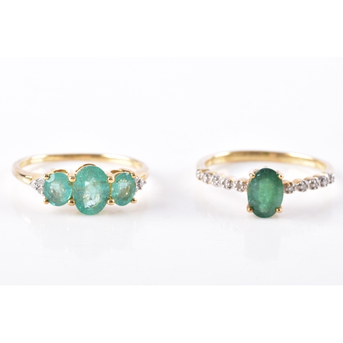 10 - A 9ct yellow gold and three stone emerald ring, the shoulders each set with three diamond accents, s... 