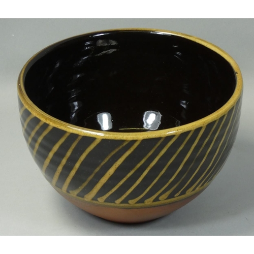 103 - Peter Dick (1936 - 2012), a small bowl with black and yellow sgraffito decoration, ochre coloured ba... 