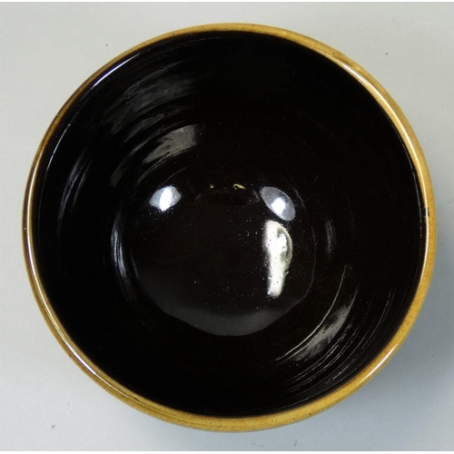 103 - Peter Dick (1936 - 2012), a small bowl with black and yellow sgraffito decoration, ochre coloured ba... 