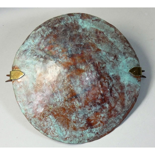 52 - Roger Barns, a patinated and hammered copper dish, with carry handle, diameter 22.5cm.