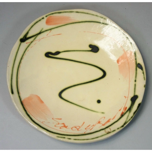 84 - Sandy Brown (b.1946), a circular plate with bold brushwork and trailed decoration, signed to the fac... 